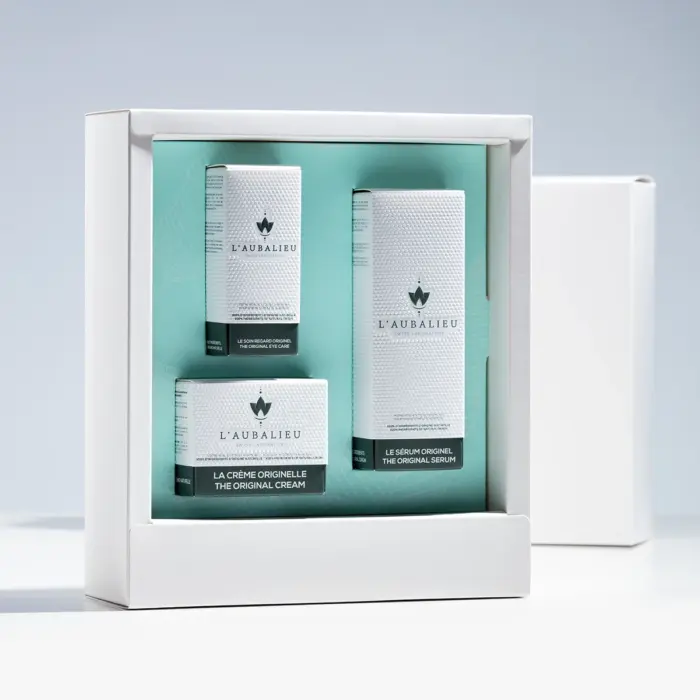 Coffret ouvert sur produit cosmétique. Coffret minimaliste accueillant 3 produits.