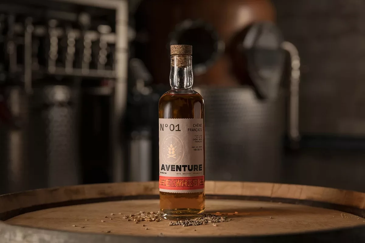 L’étiquette de la bouteille de whisky rye Aventure, présentée sur un tonneau, a été réalisée par Autajon Étiquettes Atlantique