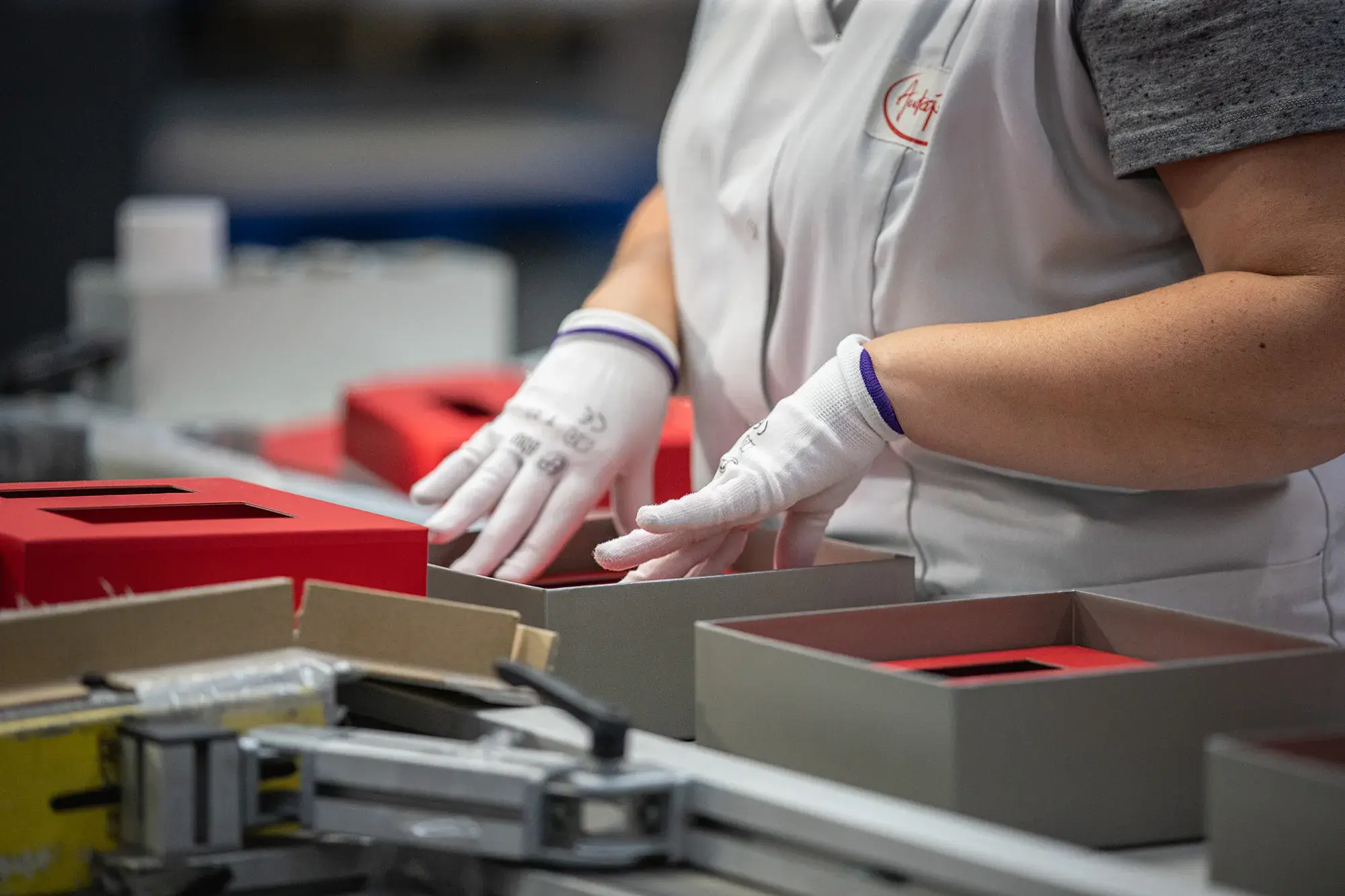 Une personne avec des gants en train de monter manuellement un coffret